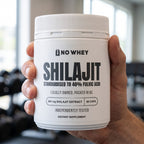 Hand holding NoWhey Shilajit 60-capsule tub in a gym